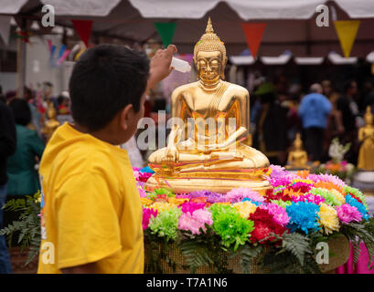 L'aspersion de l'eau parfumée de fleurs plus de statue bouddhiste pendant Songkran festival célébrant le Nouvel An Thaï, à Los Angeles, Californie.
