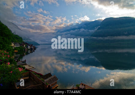 Tôt le matin, vue sur Hallsatter (voir le lac de Hallstatt) avec des reflets de nuages bas dans l'eau encore, prises d'un balcon Seehotel Gruner Baum Banque D'Images