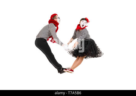 Smiling mimes en chemises à rayures. Homme et femme sautant ensemble isolé sur fond blanc Banque D'Images