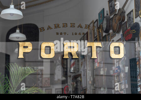 Porto d'or signer dans la fenêtre d'un barbershop​ traditionnel fait le centre de la ville. Banque D'Images