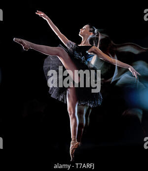 Une jeune femme de race blanche ballerine danseur isolé sur fond noir avec le light painting flou de l'effet de vitesse Banque D'Images