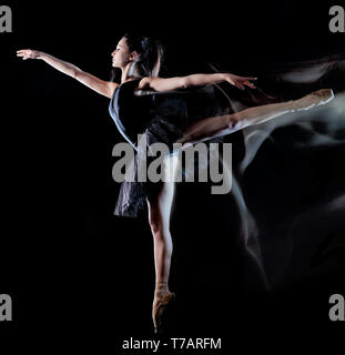 Une jeune femme de race blanche ballerine danseur isolé sur fond noir avec le light painting flou de l'effet de vitesse Banque D'Images