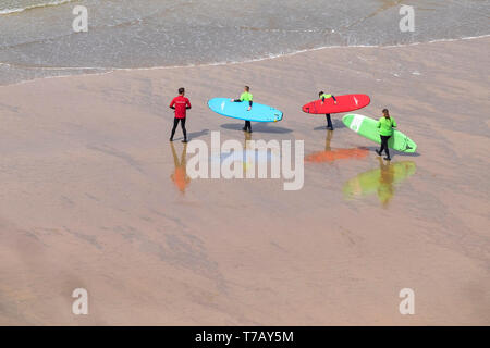 Un instructeur de surf à ses élèves à la mer pour une leçon de surf sur la grande plage de l'Ouest à Newquay en Cornouailles. Banque D'Images