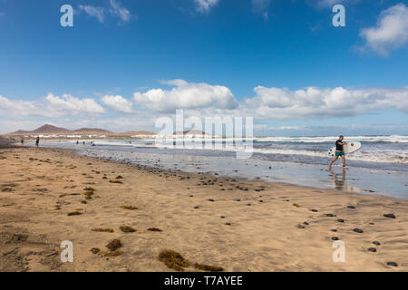 Surfer sur la plage de Famara, Lanzarote, Îles Canaries Banque D'Images