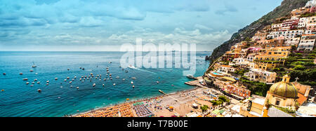 Vue panoramique à partir de ci-dessus, maisons à flanc de montagne, sur la plage, la mer turquoise plein de parasols transats touristes gens profiter de l'été. Positano Banque D'Images