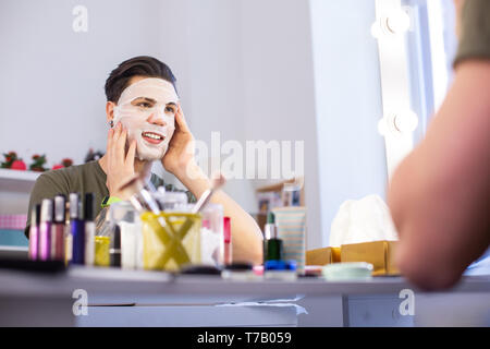 Smiling beau mec profiter de nouveaux produits de beauté Banque D'Images