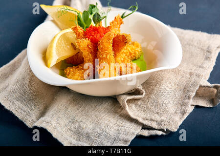 Crevettes frites dans la pâte avec la sauce aux épinards Banque D'Images