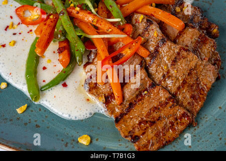 Les steaks grillés aux asperges, poivrons et carottes en sauceserved crème au restaurant Banque D'Images