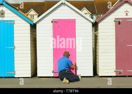 Un homme prend son temps de peindre ses beach hut sur front de mer de Paignton. Peter Lopeman/Alamy Live News Banque D'Images