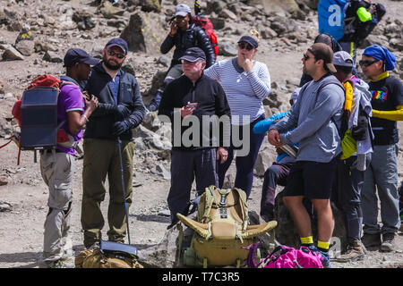 Brave et extrême groupe de touristes ayant un reste entre les longues marches et monter à la montagne. De manger ou de s'asseoir sur leurs sacs, fatigué. Le port de caps Banque D'Images