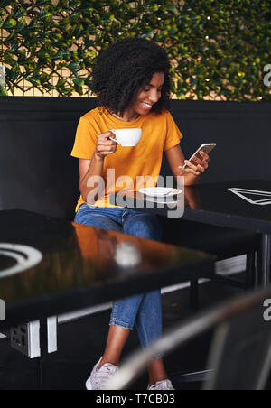 Tasse de café woman using mobile phone in cafe Banque D'Images