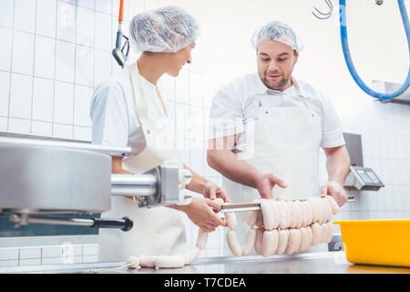 Équipe de bouchers dans l'industrie de la viande de saucisse de remplissage Banque D'Images