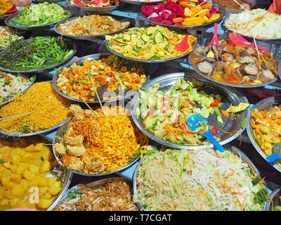 Buffet végétarien menu sur le marché de rue à Luang Prabang au Laos, Asie du sud-est. Des plats variés, colorés présentés sur plusieurs plaques. Banque D'Images