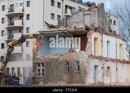 Ancien bâtiment de trois étages résidentiels avec Pelle de démolition Banque D'Images