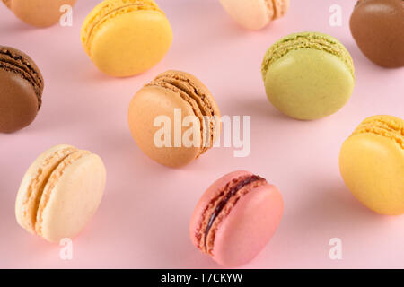 Macarons sur fond pastel. Macarons français classique avec des goûts différents. Banque D'Images