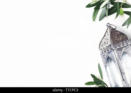 L'argent, l'Arabe marocain Vintage lanterne. Olive verte de feuilles d'arbres et branches isolé sur fond de table blanc, cartes de vœux pour la fête musulmane de Ram Banque D'Images