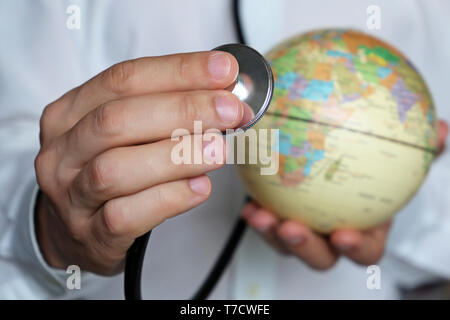 Doctor with stethoscope et un globe dans ses mains. Les soins de santé en Afrique, concept de la médecine, le contrôle des épidémies, la vaccination Banque D'Images