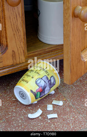 Tasse à café photographes pose sur carrelage avec poignée cassée après une chute d'armoire concept manque de concentration Banque D'Images