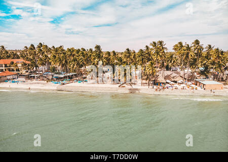 La plage dans le village de Mui Ne. Palmiers, des maisons de villégiature, ses cafés. Province de Binh Thuan, Phan Thiet, Vietnam Banque D'Images