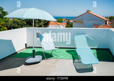 Les chaises longues et parasols sur la terrasse l'été avec un luxe sur la mer de l'Atlantique à Cascais, Portugal. Banque D'Images
