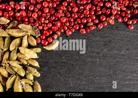 Beaucoup de vrai entier et pod cardamome poivre rose péruvien sur flatlay pierre gris Banque D'Images