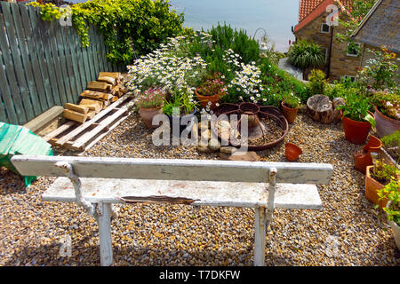 Un charmant petit jardin dans une petite maison de vacances avec une banquette donnant sur la mer à Runswick Bay North Yorkshire Banque D'Images