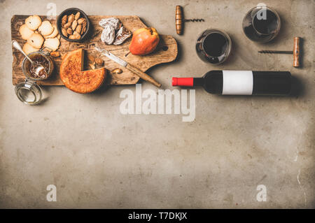 Vin et snack-set. Télévision à jeter de bouteille de vin avec étiquette vierge, vintage tire-bouchons, verres à vin, fromage et apéritifs à bord sur le béton Retour Banque D'Images