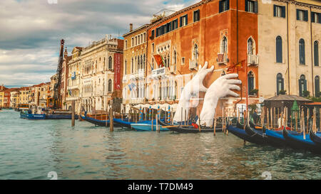 Les mains géantes sculpture par Lorenzo Quinn semble tenir le bâtiment le long du Grand Canal à Venise, Italie l'appui montre le souci de l'effe Banque D'Images