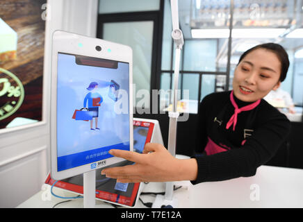 (190507) -- BEIJING, 7 mai 2019 (Xinhua) -- L'employé démontre un paiement de reconnaissance faciale, surnommé 'Dragonfly' équipement à une boulangerie à Beijing, capitale de Chine, le 27 décembre 2018. L'économie numérique de la Chine a atteint 31,3 milliards de yuans (4 600 milliards de dollars américains) en 2018, représentant 34,8 pour cent du PIB total, selon un rapport publié par l'Administration chinoise de cyberespace le lundi. Dévoilé à la 2e Sommet Chine numérique en cours dans le sud-est de la ville de Fuzhou, le rapport montre que le système d'innovation du pays a été constamment améliorée, comme l'o Banque D'Images