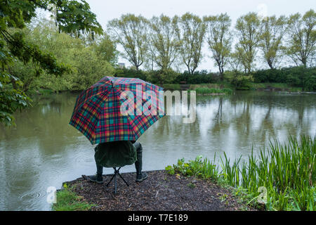 Billingham, Stockton on Tees, UK. 7e mai 2019. Météo France : Pêche sous la pluie par une froide et humide mardi matin à Charlton's Pond de Billingham, dans le nord est de l'Angleterre. Credit : Alan Dawson/Alamy Live News Banque D'Images