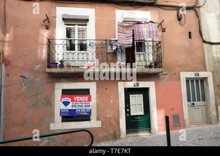 Vue extérieure d'un à vendre vendôme signe sur une maison traditionnelle dans la vieille ville avec buanderie à l'extérieur de l''Alfama Lisbonne Portugal Europe UE KATHY DEWITT Banque D'Images