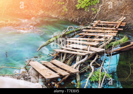 Sentier de randonnée dans la pittoresque vieille planche en bois pont sur ruisseau de montagne propre avec eau turquoise. Paysage naturel et paisible wit Banque D'Images