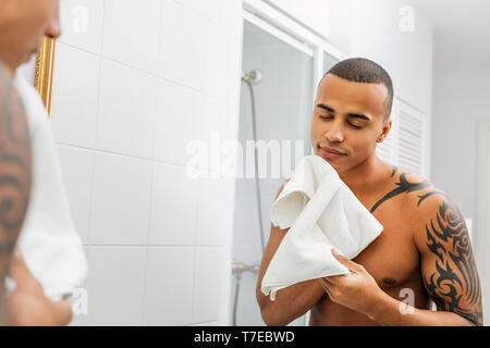 Handsome man holding serviette blanche avec les yeux fermé après le rasage Banque D'Images