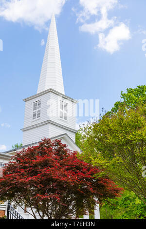 Nashville, TN, USA-4/28/19 : clocher de l'Église, aux couleurs rouge et vert printemps arbres en premier plan, ciel bleu ensoleillé. Banque D'Images