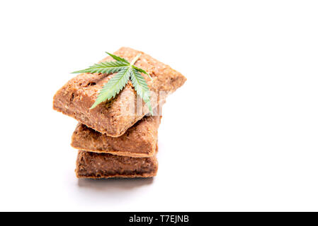 Friandises pour chiens et le cannabis feuilles isolées sur fond blanc - CBD et de la marijuana médicale pour animaux domestiques concept Banque D'Images