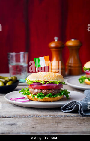 Burger avec drapeau irlandais sur le dessus. Fond de bois. Copier l'espace. Banque D'Images