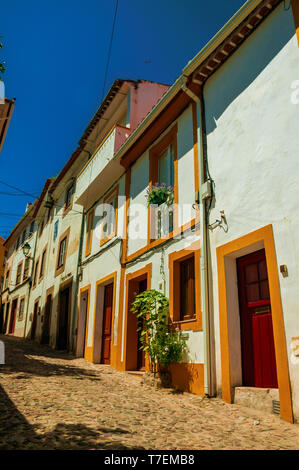 Façade de vieille maisons colorées avec mur dans ruelle sur pente à Castelo de Vide. Belle ville avec château médiéval à la frontière orientale du Portugal. Banque D'Images