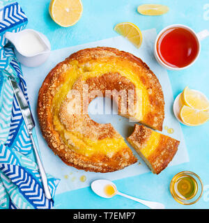 Gâteau bundt citron avec une tasse de thé. Fond bleu. Vue d'en haut. Banque D'Images