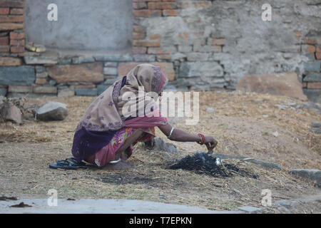 Woman balancing des cow-dung sur la tête à l'exécution pour le séchage et l'a utilisé pour faire du feu Banque D'Images