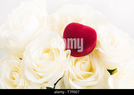 Boîte à bijoux cadeaux rouge sur le bouquet de roses blanches. Valentines Day gift concept. Inscrivez-romantique. Cadeau de mariage. Signe d'amour Banque D'Images