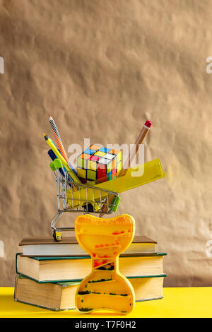 Concept Retour à l'école. Pile de livres avec des fournitures scolaires dans le panier. Banque D'Images