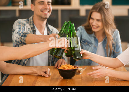 Groupe d'amis gais de boire une bière en bar Banque D'Images