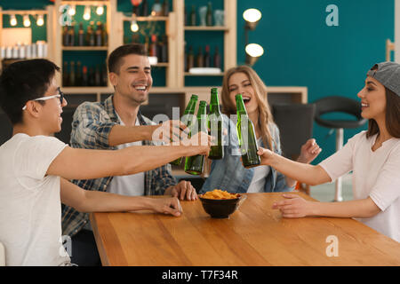 Groupe d'amis gais de boire une bière en bar Banque D'Images