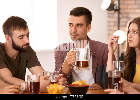 Les amis de boire une bière en bar Banque D'Images