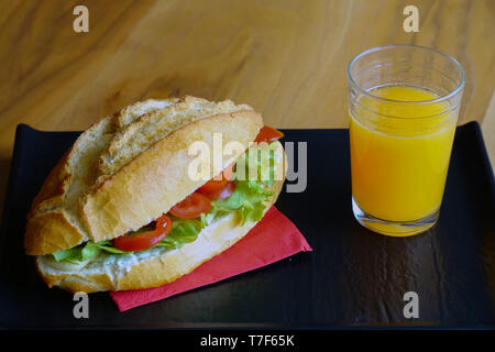 Sandwich et jus d'orange pour le petit déjeuner préparé à la maison sur fond de bois Banque D'Images