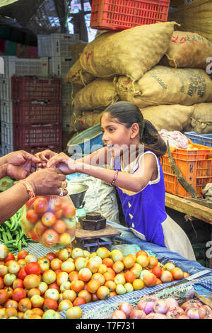 Jeune fille travaillant dans un marché local desservant le secteur des fruits et légumes d'un décrochage à Shahpura, Dindori, central de l'état indien de Madhya Pradesh Banque D'Images