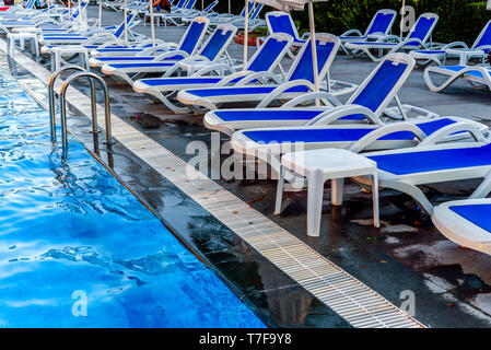 La piscine avec chezlongs bleu piscine et vue en gros Banque D'Images