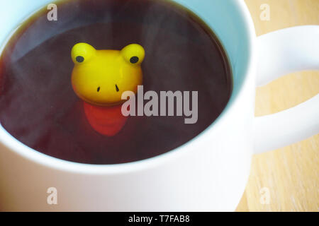 Figurine grenouille mignon dans le mug blanc avec base de Sunny Banque D'Images