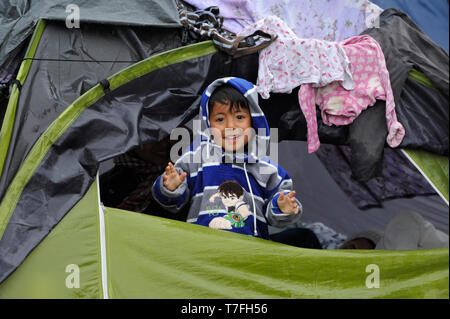 Le Pirée, Grèce. 27 mars 2016. Un enfant se profile à partir d'une tente sur le port du Pirée où plus de 5 000 réfugiés et migrants sont bloqués. Banque D'Images