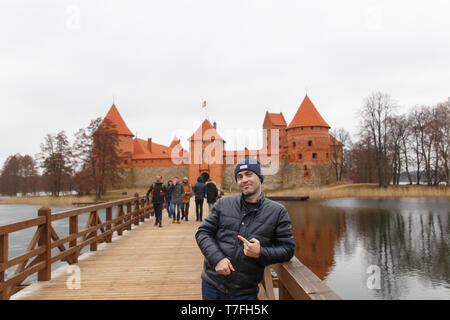 Jeune homme posant sur le pont à l'île de Trakai Castle Banque D'Images